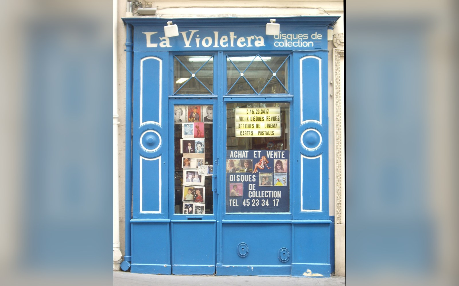 Blue-painted storefront of La Violetera record shop with posters in the window